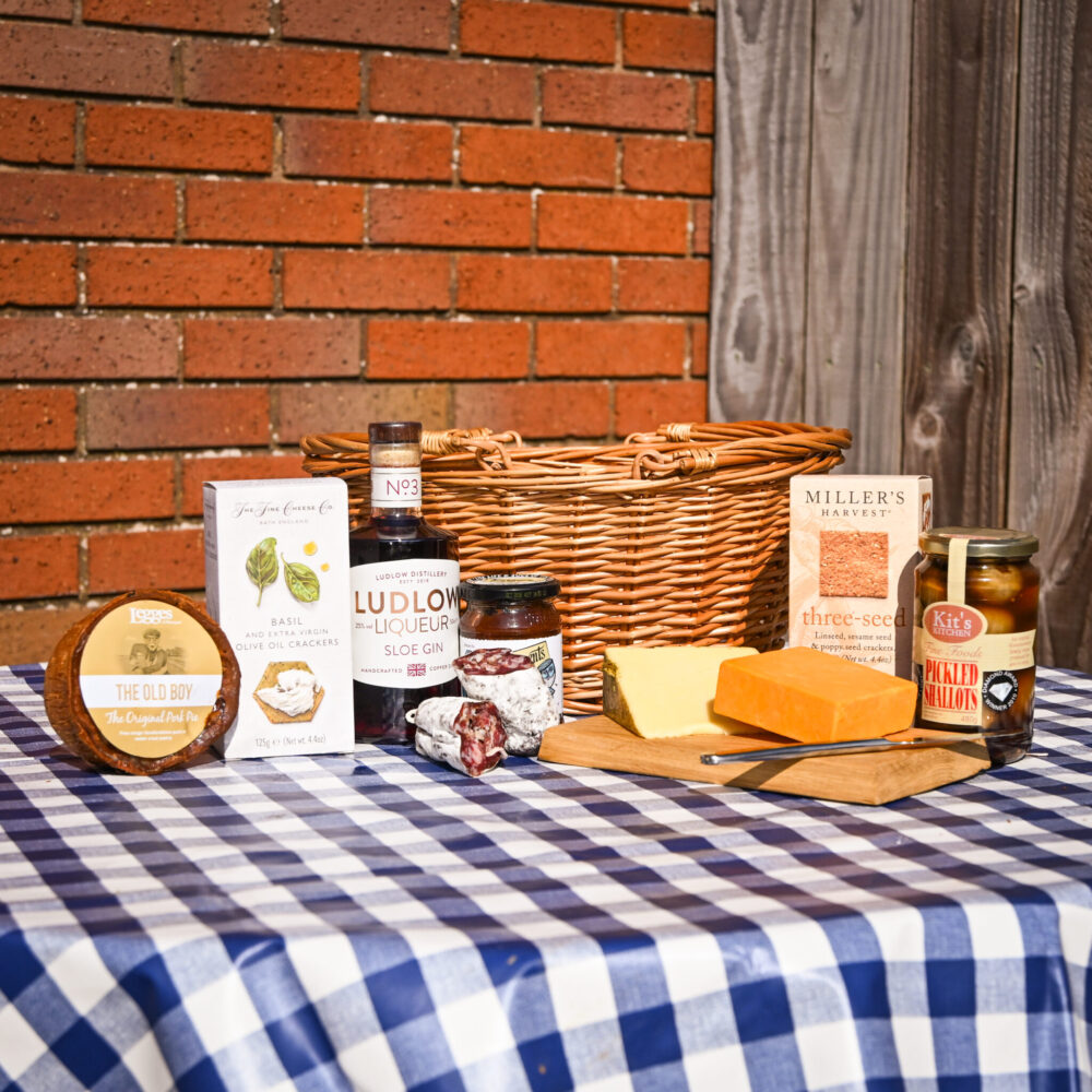 A gift hamper from Herefordshire filled with local cheese, crackers, sloe gin, pickled onions, salami, and a handmade pork pie.