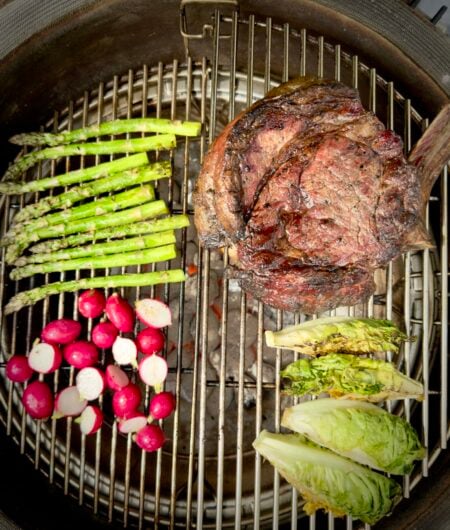 Hereford Tomahawk steak on the BBQ with fresh, seasonal produce